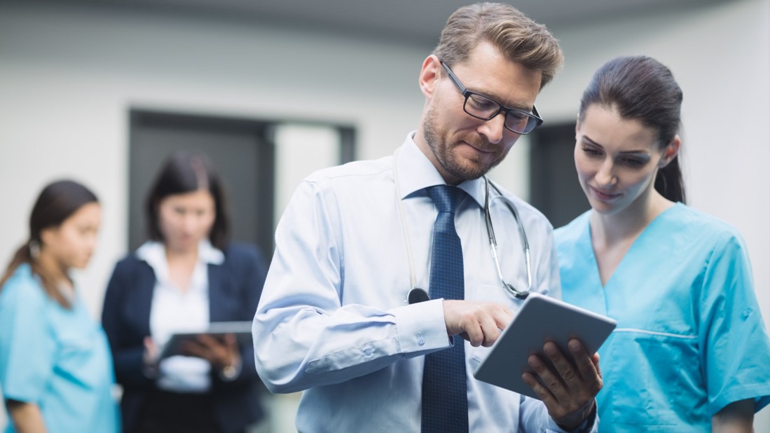 Arzt und medizinisches Personal mit Tablet